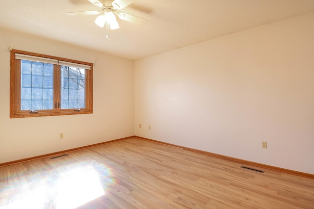 unfurnished room featuring visible vents, ceiling fan, baseboards, and light wood-style floors