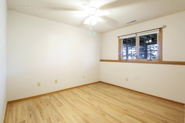 unfurnished room featuring ceiling fan, wood finished floors, baseboards, and a textured ceiling