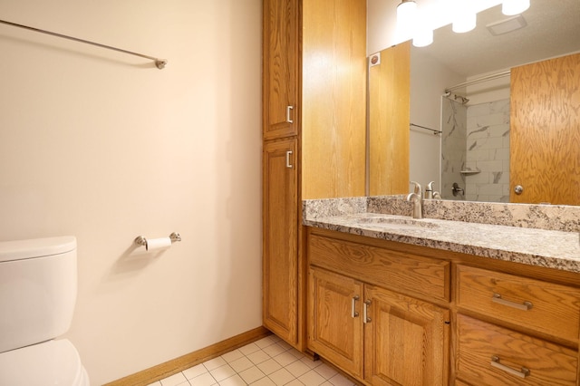 bathroom with tile patterned floors, toilet, baseboards, walk in shower, and vanity