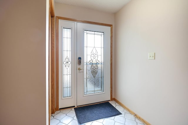 foyer entrance featuring baseboards