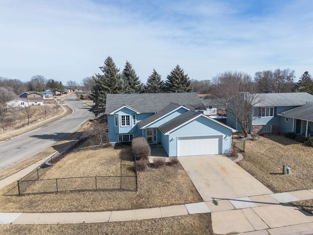 view of front facade featuring concrete driveway, a garage, and a fenced front yard