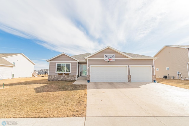 view of front of property with a front yard, an attached garage, and driveway