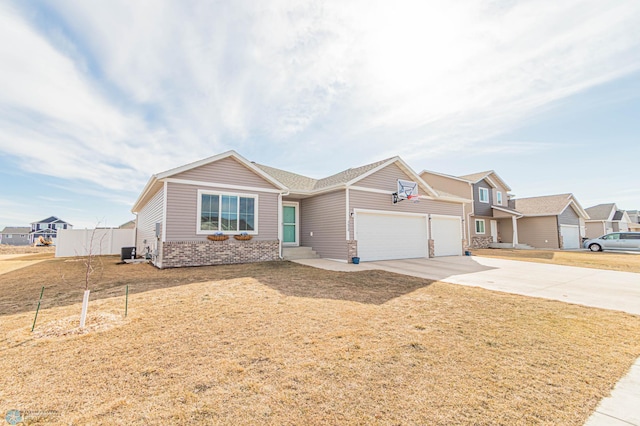 view of front of home featuring brick siding, an attached garage, a front lawn, central air condition unit, and driveway