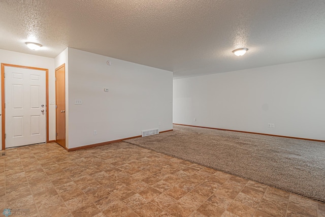 empty room with visible vents, baseboards, light colored carpet, and a textured ceiling