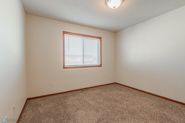 unfurnished room featuring visible vents, baseboards, carpet, and a textured ceiling