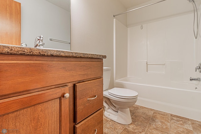 bathroom with stone finish flooring, toilet, vanity, and washtub / shower combination