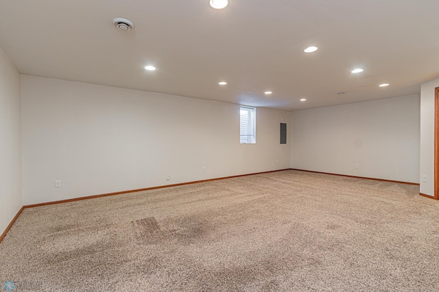 unfurnished room featuring electric panel, light colored carpet, recessed lighting, and baseboards