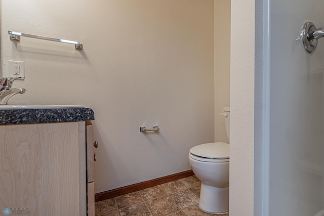 bathroom with toilet, baseboards, and a sink