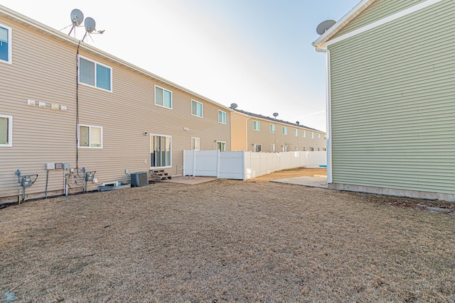 back of property with central AC and fence