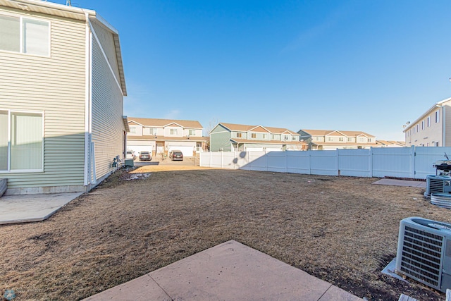 view of yard with cooling unit, a fenced backyard, and a residential view