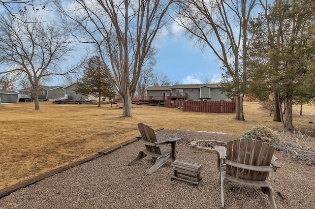 view of yard featuring a fire pit, a deck, and fence