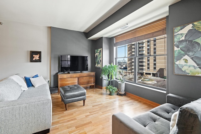 living room with visible vents, wood finished floors, and baseboards