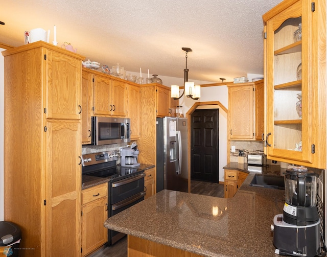 kitchen featuring a chandelier, decorative backsplash, a peninsula, a textured ceiling, and stainless steel appliances