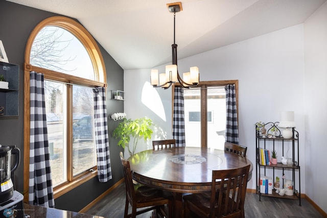 dining area with a notable chandelier, dark wood-type flooring, baseboards, and vaulted ceiling