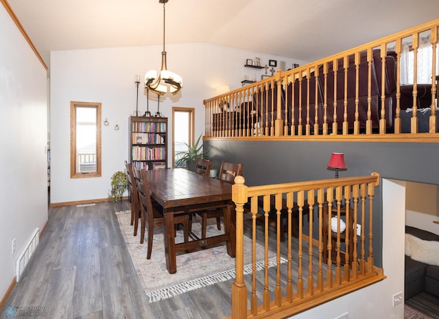 dining room featuring visible vents, baseboards, lofted ceiling, wood finished floors, and a notable chandelier