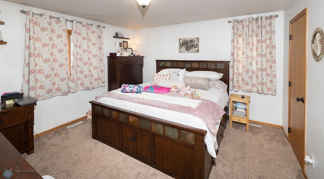 bedroom with baseboards, carpet floors, and a textured ceiling