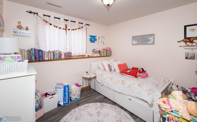 bedroom with visible vents and wood finished floors