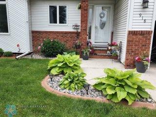 entrance to property featuring brick siding and a yard