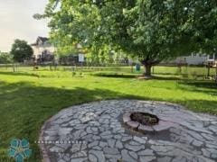 view of community with a yard, a patio, and an outdoor fire pit