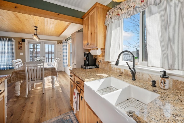 kitchen with light stone countertops, a sink, wood-type flooring, wooden ceiling, and decorative light fixtures