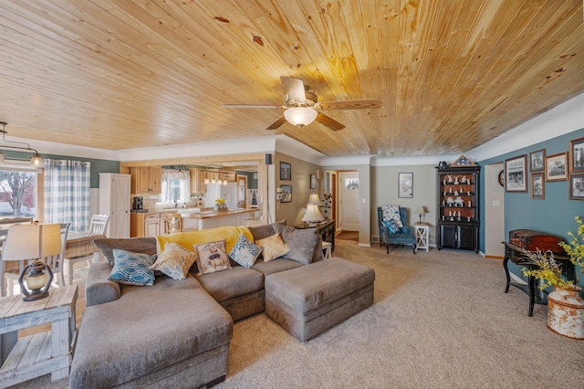 living area with plenty of natural light, light colored carpet, wood ceiling, and a ceiling fan