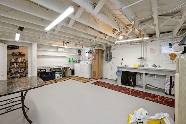 unfinished below grade area featuring a workshop area, electric panel, separate washer and dryer, and water heater