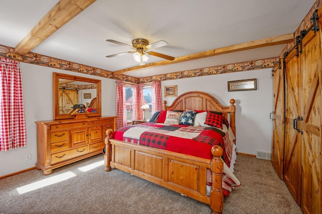 bedroom featuring a barn door, beamed ceiling, carpet, and visible vents