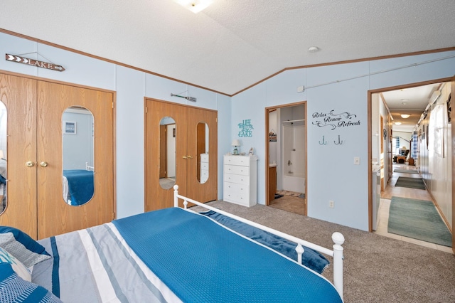 bedroom featuring a textured ceiling, connected bathroom, carpet flooring, crown molding, and lofted ceiling