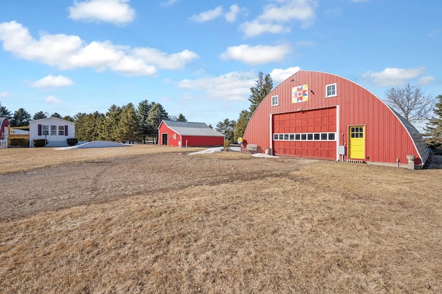 view of pole building featuring a lawn and driveway