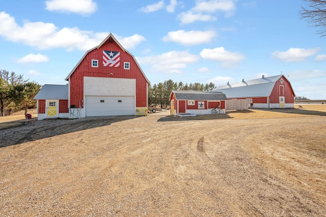 view of barn featuring dirt driveway