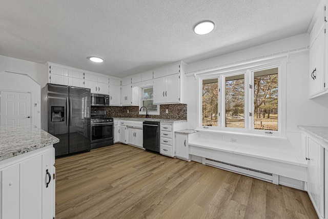 kitchen featuring decorative backsplash, light wood-style flooring, stainless steel appliances, and a sink