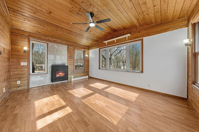 unfurnished living room featuring plenty of natural light, baseboard heating, wood ceiling, and a glass covered fireplace