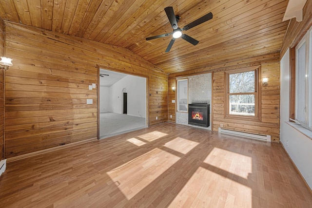 unfurnished living room featuring a glass covered fireplace, wooden walls, a baseboard radiator, lofted ceiling, and wood ceiling