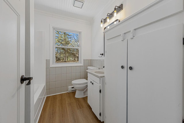 full bathroom with vanity, wood finished floors, crown molding, tile walls, and toilet