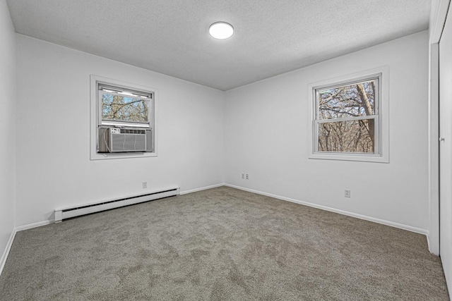 carpeted empty room featuring a baseboard heating unit, cooling unit, a wealth of natural light, and a textured ceiling