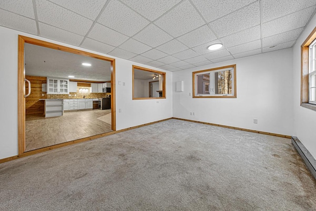 unfurnished living room featuring baseboards, carpet floors, and baseboard heating