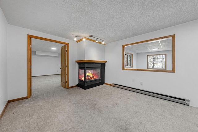 carpeted empty room with a baseboard heating unit, a multi sided fireplace, baseboards, and a wall mounted AC