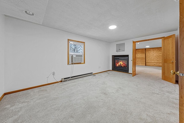 unfurnished living room with a textured ceiling, a glass covered fireplace, carpet, a baseboard radiator, and baseboards