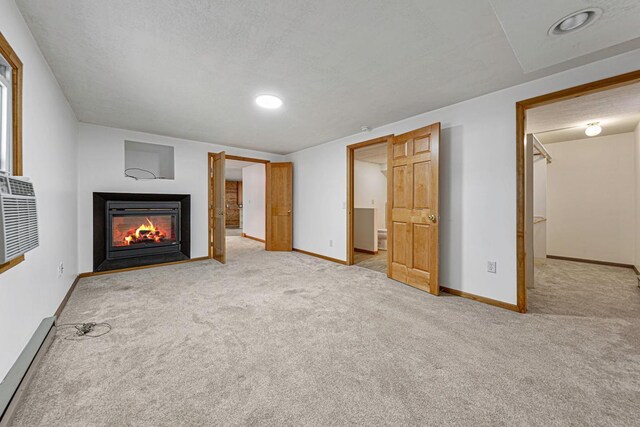 unfurnished living room with baseboards, a multi sided fireplace, carpet floors, and a baseboard radiator