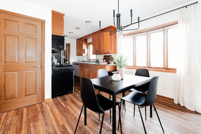 dining room with light wood-style flooring, recessed lighting, baseboards, and a chandelier