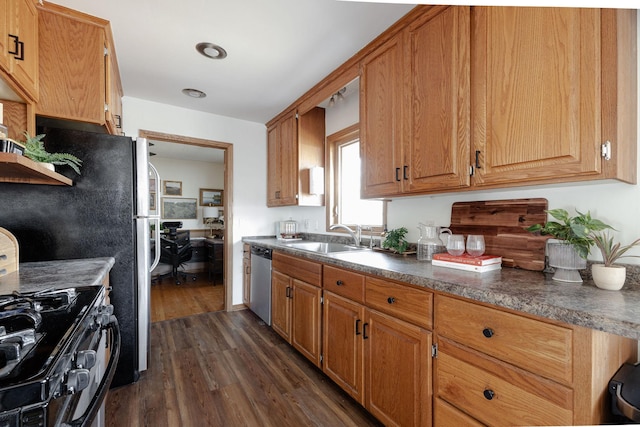 kitchen featuring black gas stove, dark wood-style flooring, a sink, dishwasher, and dark countertops