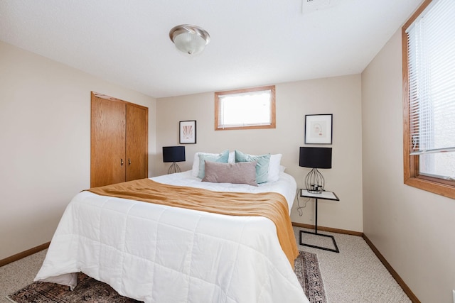 carpeted bedroom featuring a closet, visible vents, and baseboards