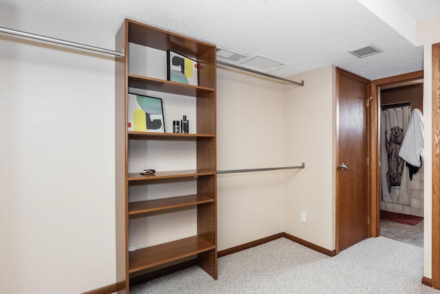 walk in closet featuring visible vents and carpet floors