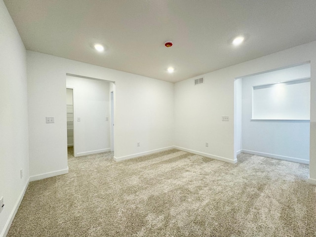 spare room with visible vents, recessed lighting, baseboards, and light carpet