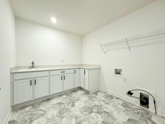 laundry room with a sink, baseboards, cabinet space, and hookup for a washing machine