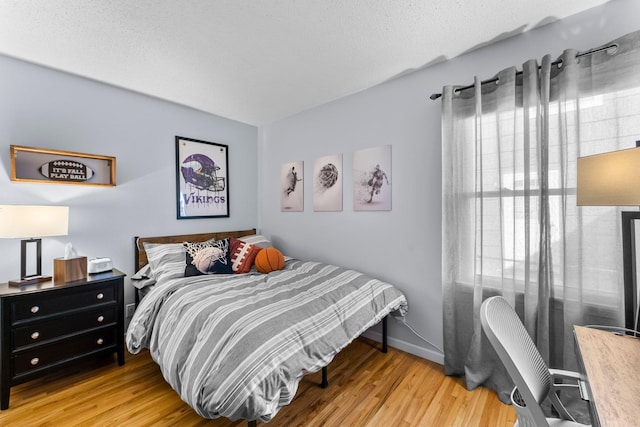 bedroom with baseboards and wood finished floors