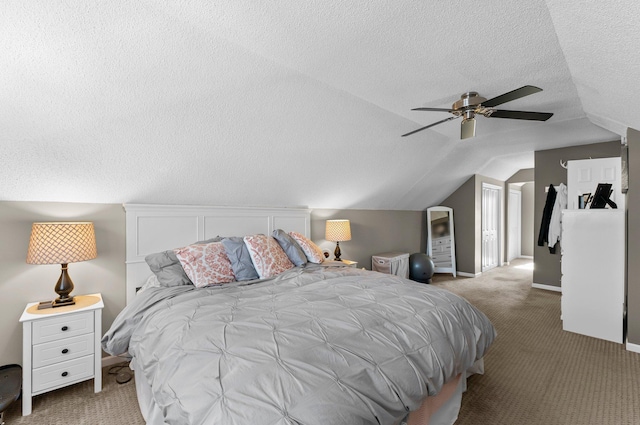 bedroom with a ceiling fan, a textured ceiling, carpet flooring, and vaulted ceiling