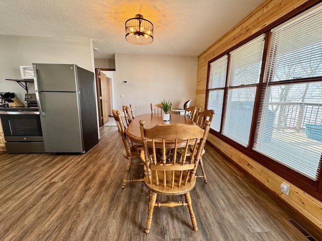 28887 Hi Vista Dr, Otter Tail Twp, MN 56515 - dining space with dark wood finished floors, a chandelier, a textured ceiling, and wooden walls