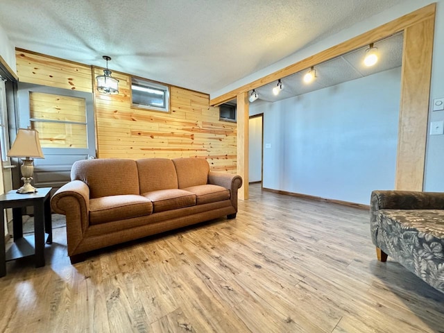 28887 Hi Vista Dr, Otter Tail Twp, MN 56515 - living room with wooden walls, wood finished floors, a textured ceiling, track lighting, and baseboards