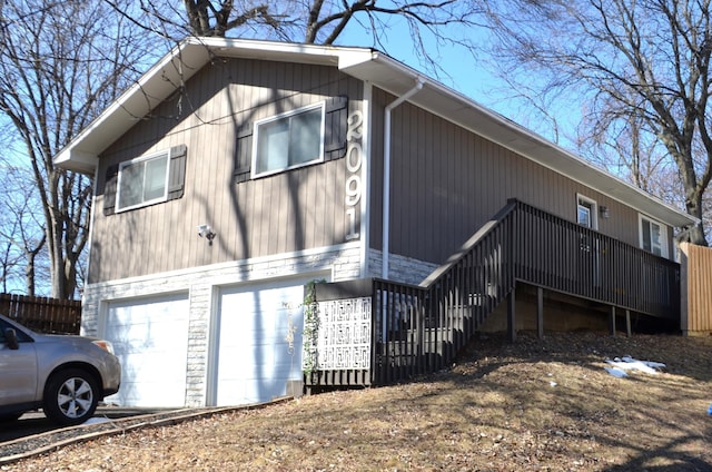 view of home's exterior featuring an attached garage and fence